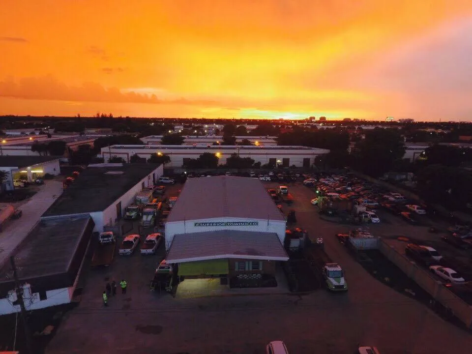 Aerial view of A Superior Towing's secure vehicle storage facility in Davie, FL, at dusk.